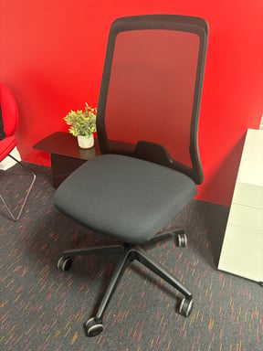 Re-upholstered task chair with a recovered grey seat pad, returned to the office floor